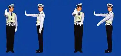 图中警察手势为左转弯信号。
