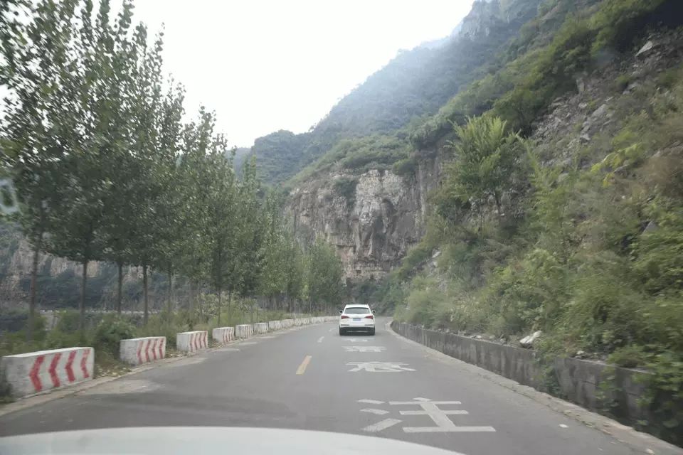 如图所示，驾驶机动车在这种落石多发的山区道路行驶，以下说法正…