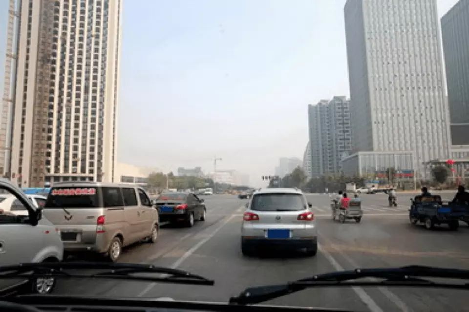 驾车驶近图中路口时，应保持视线移动，时刻关注周围潜在危险。